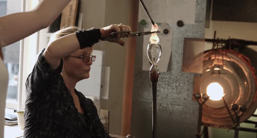 Glass artisans spinning molten glass
