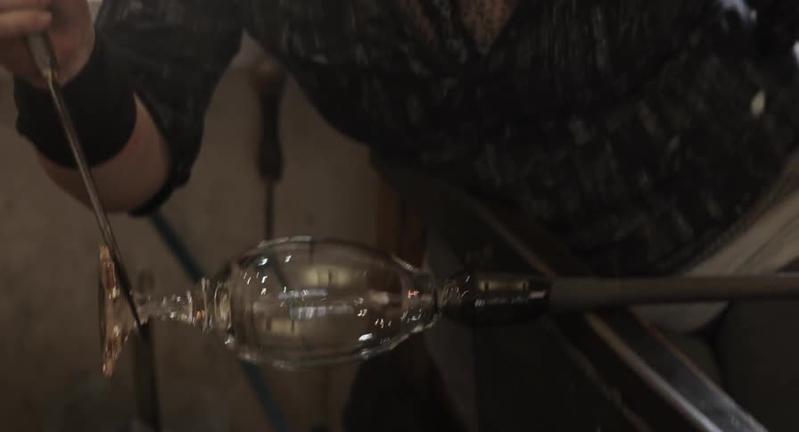Close up of a woman spinning hot glass into a wine glass