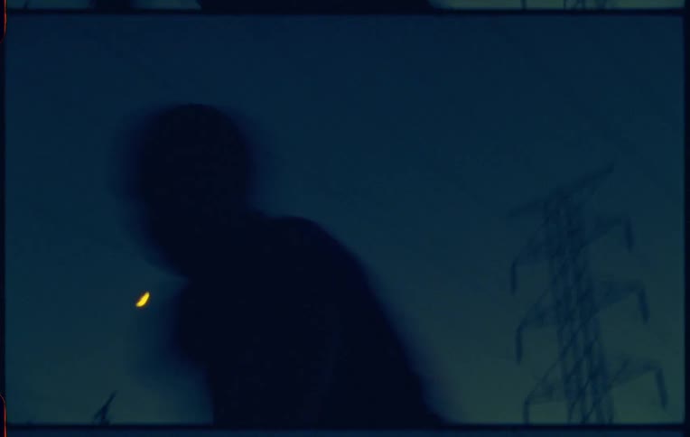 Man dances frenetically under power lines at night
