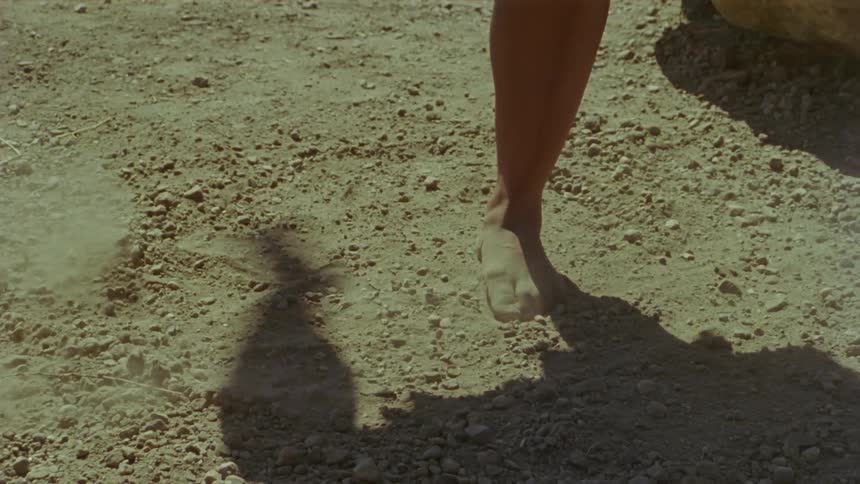 Woman dancing barefoot kicking dust clouds over the dirt