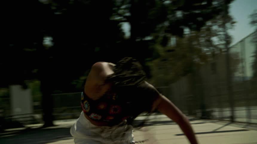 Young long haired woman dancing and spinning on a public park