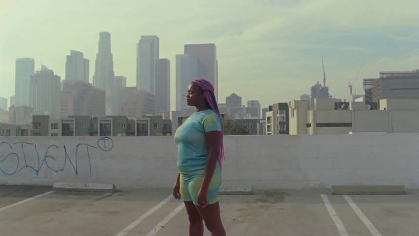 A woman is standing in the parking lot outside