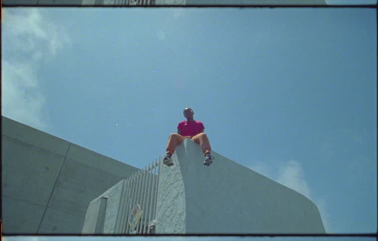 A woman is sitting on the tall wall