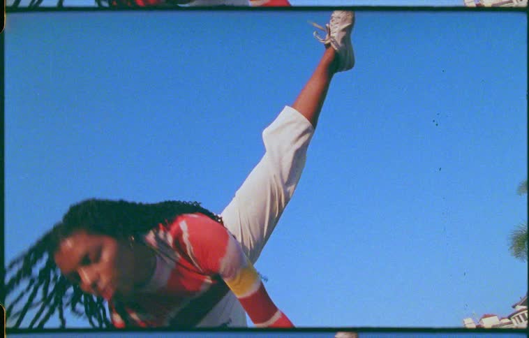 A young woman dancing by herself outdoors at daytime