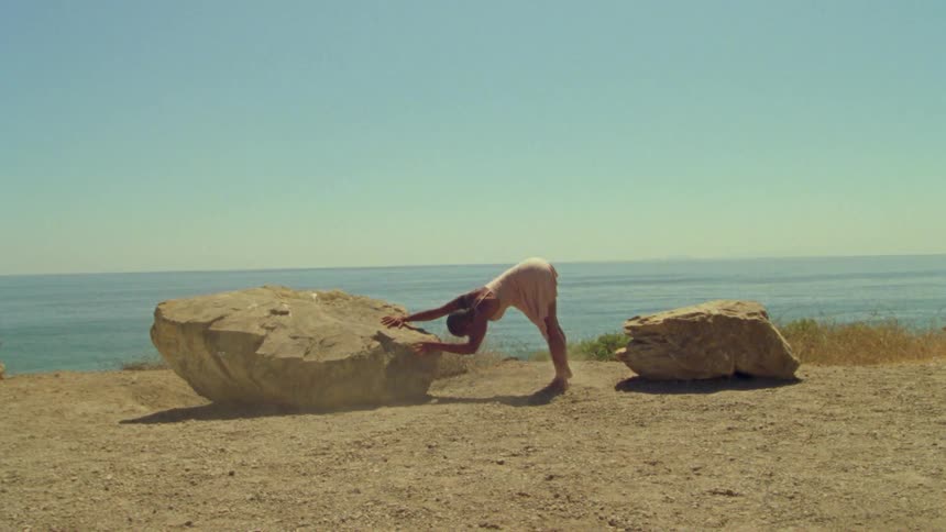 A teenage girl dances on the beach