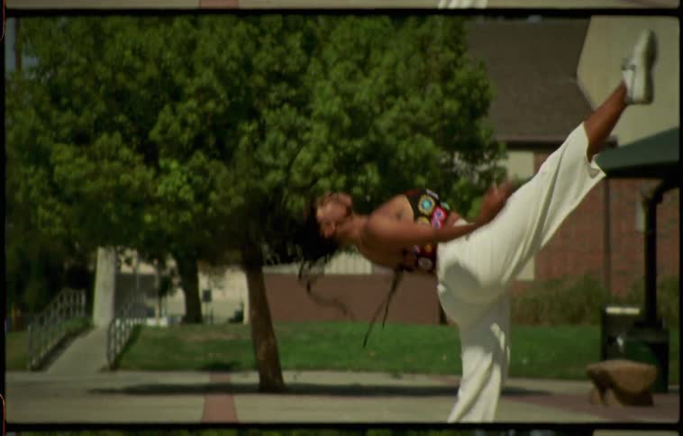A woman is dancing outdoors by a building in spring