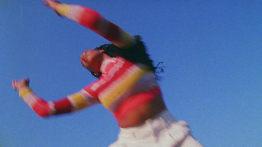 A woman is dancing outdoors during midday