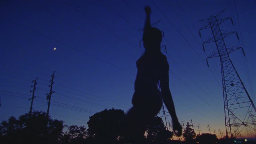 A woman dancing around outdoors at night