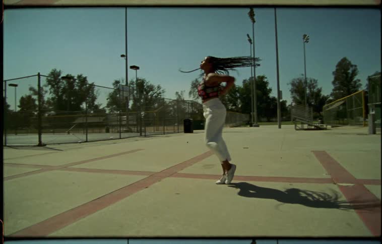 A teenage girl dancing at a park
