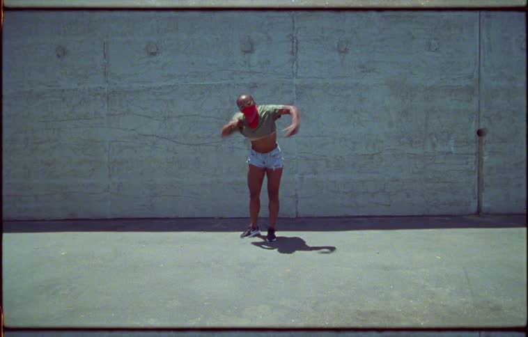 A teenager dances with a mask covering her face