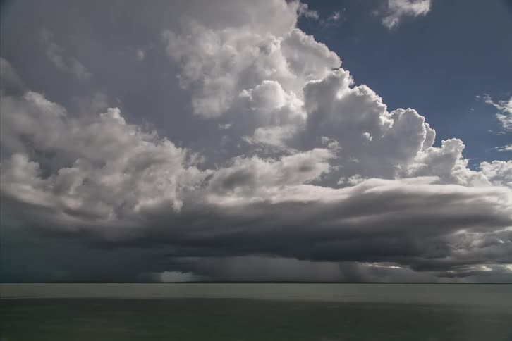 Cumulus clouds move across the sky on a very cloudy day