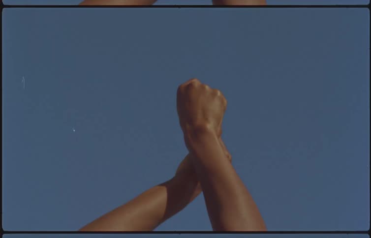 A person with their hands raised in the air rubs them together