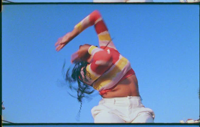 Footage of a woman dancing outdoors is displayed