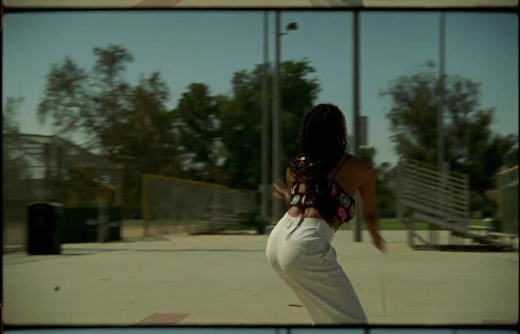 Young long haired woman dancing acrobatically on a public park