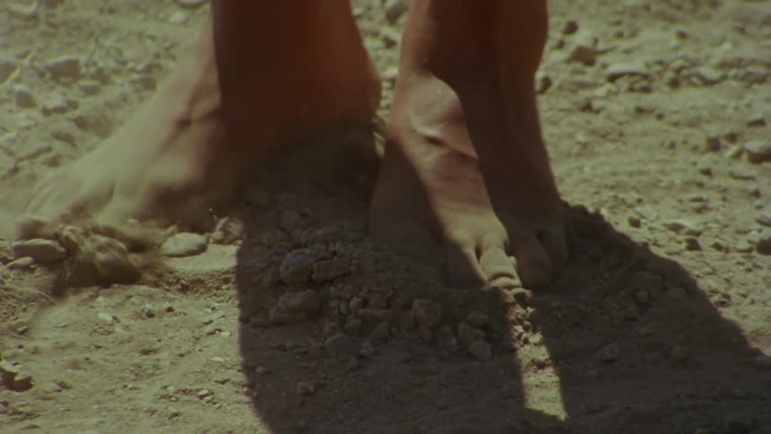 Woman dancing barefoot kicking dust clouds over the dirt