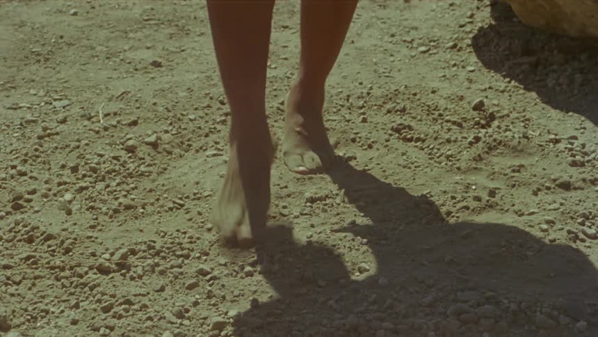 Woman dancing barefoot kicking dust clouds over the dirt