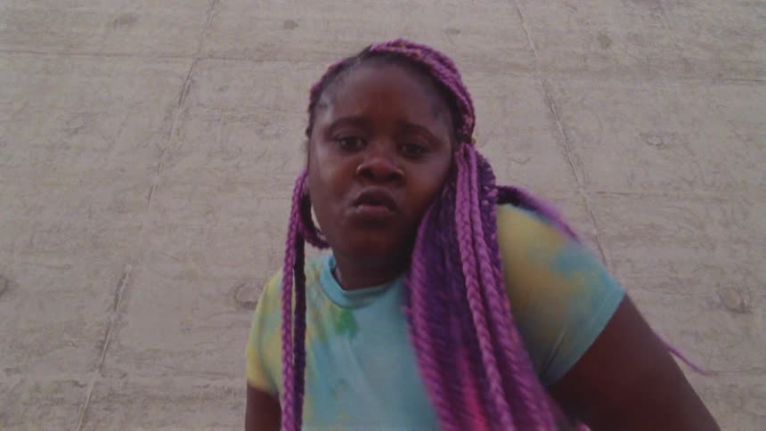 A teenage girl dancing outside on concrete