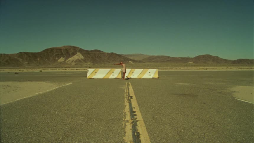 A woman dancing outside on tarmac