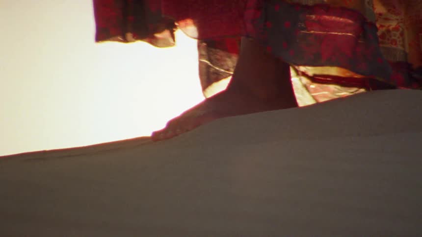 A woman walking in a sand dune