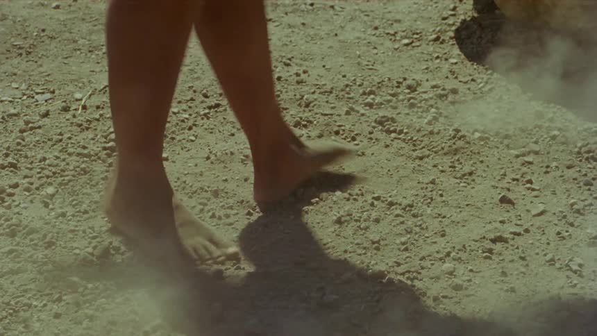 A person spins their feet around in the dirt