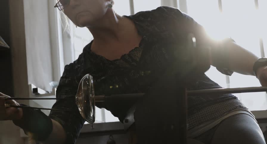 A woman is spinning glass on a pole