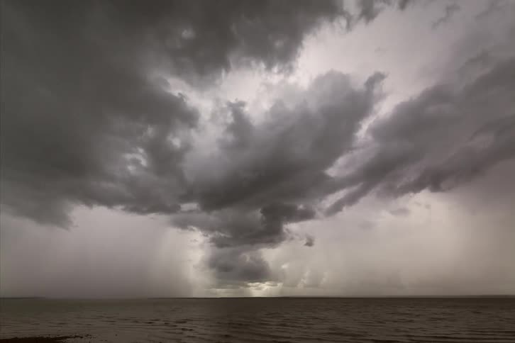 Time lapse of storm clouds moving around over a large body of water