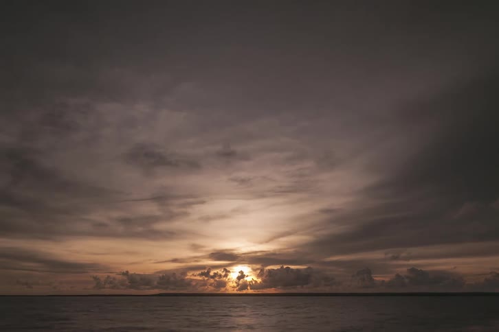 Sunset in a cloudy hazy sky over ocean