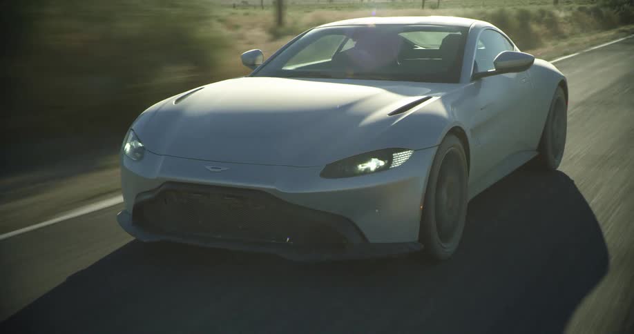A car driving on a street next to fields
