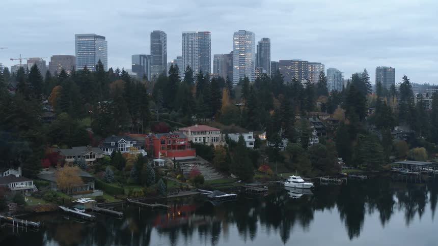 Ascending over opulent waterfront mansions toward downtown Bellevue