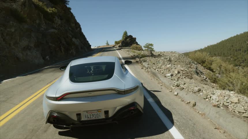 A car driving down a road in the hills