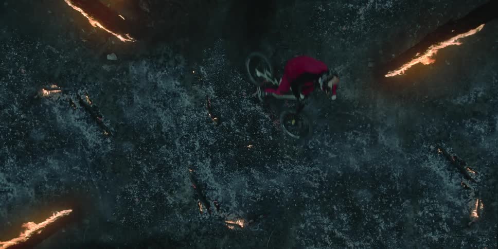 Bird's eye angle of a person riding their bike over ember pile.