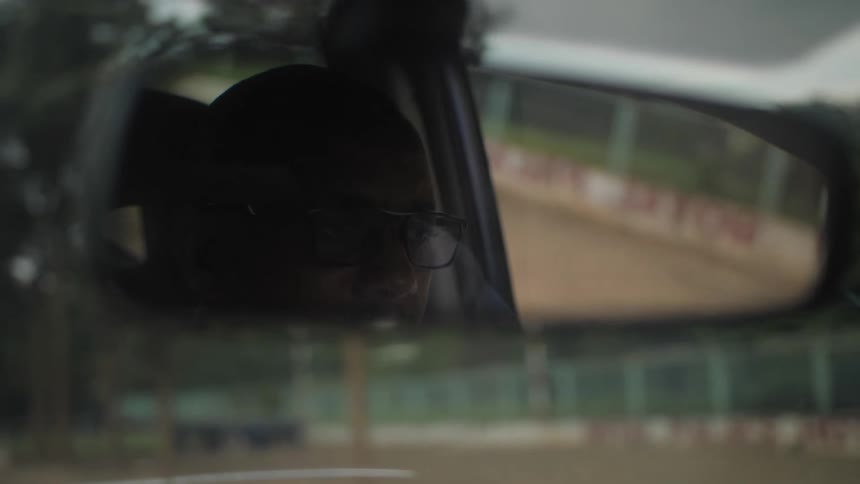 A man drives a vehicle down a road during the day