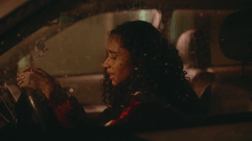 A woman is crying and singing in her car