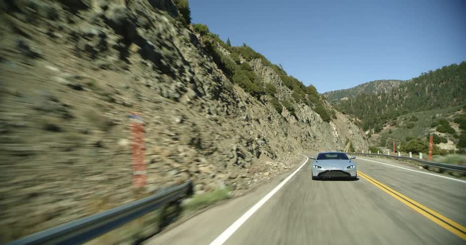 A car is driving in a rural area during the day
