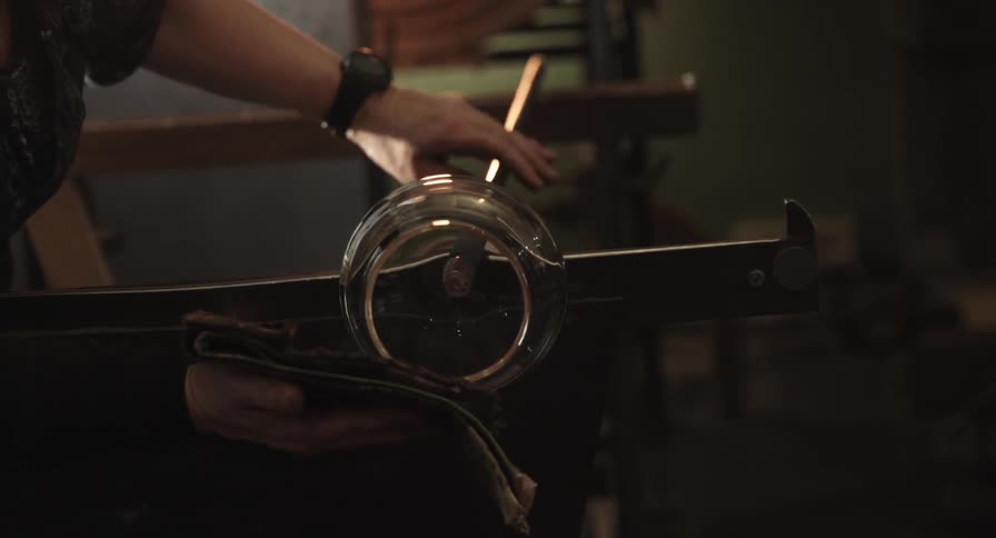 A woman rolls a piece of glass