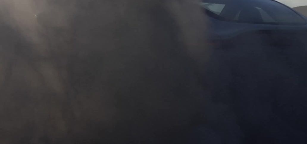 A view of a car doing doughnuts on a dirt area