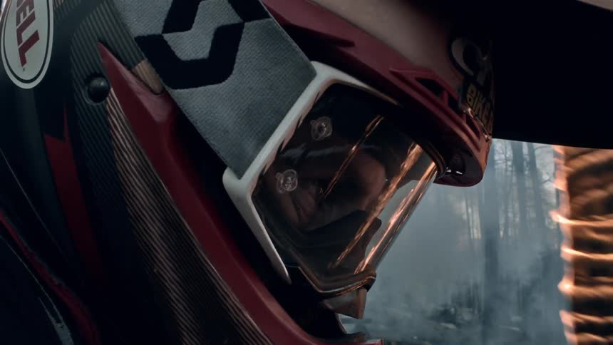 Close up of the helmet and eyes of a cyclist riding through a burning forest