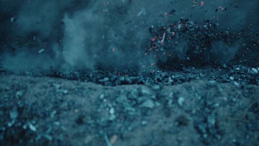 A mountain bike kicks up ash and embers through corner.