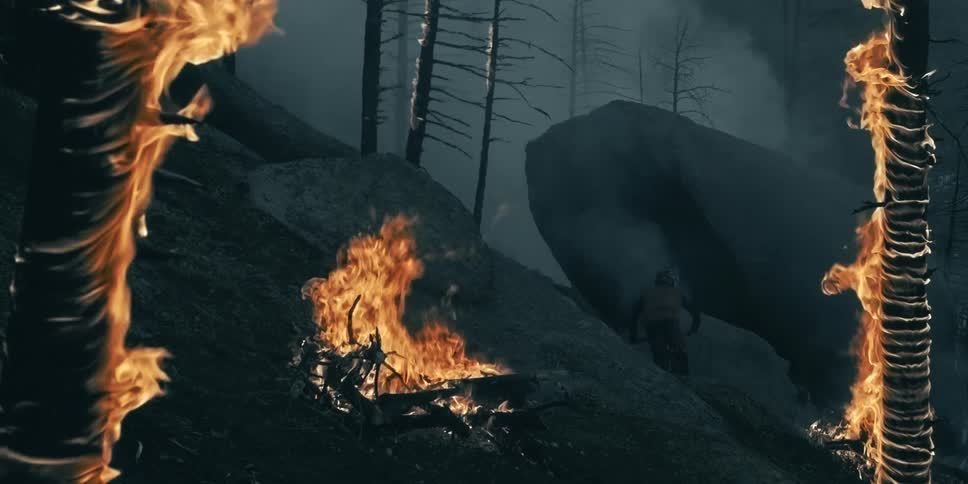 A mountain biker hits a rock wall ride in a burning forest and ash