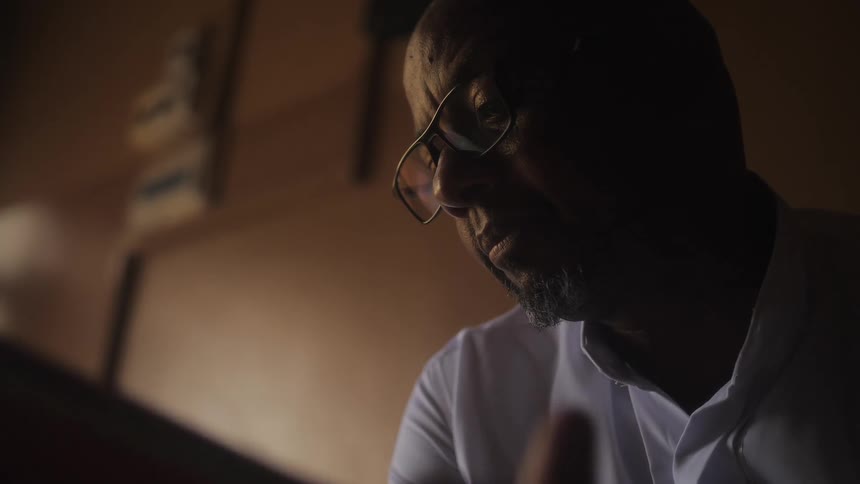A man is sitting in a room and looking at something
