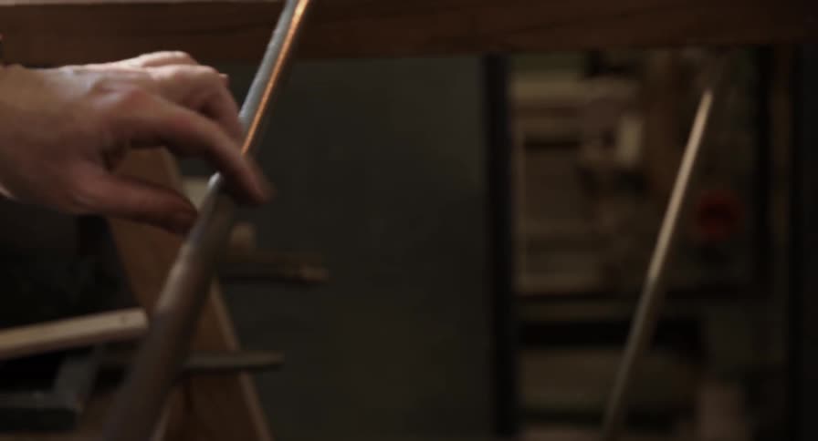 A hand rolls a metal bar