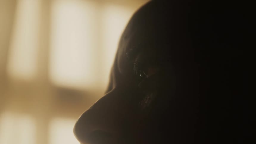 Man stares while his skin shines from light sweat and oil