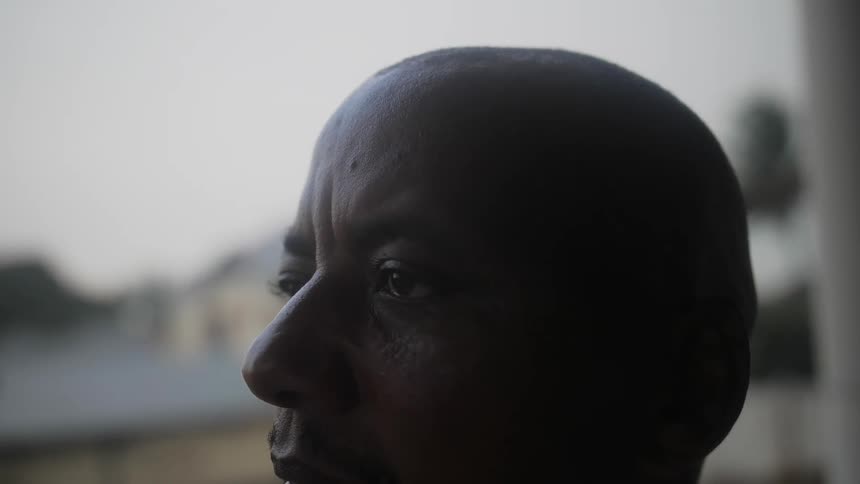 Face of a man who is staring off into the distance sadly