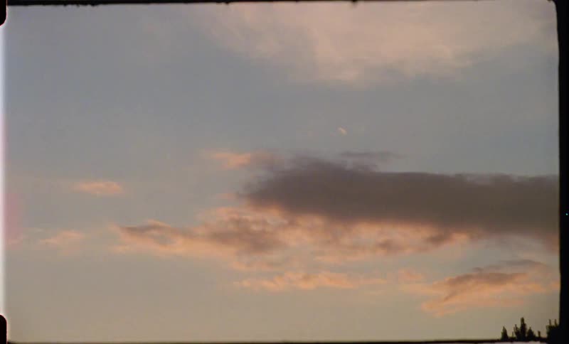 Birds fly through cloudy skies on vintage footage that suddenly glows and turns hot pink