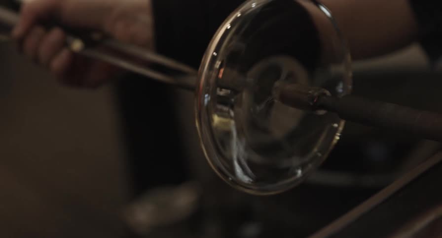 A person works on making glass