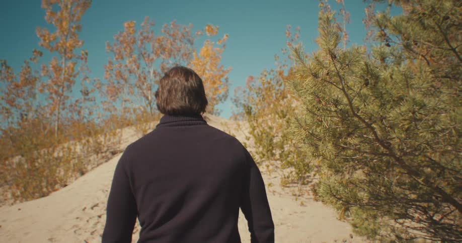 A man is hiking outdoors during the day
