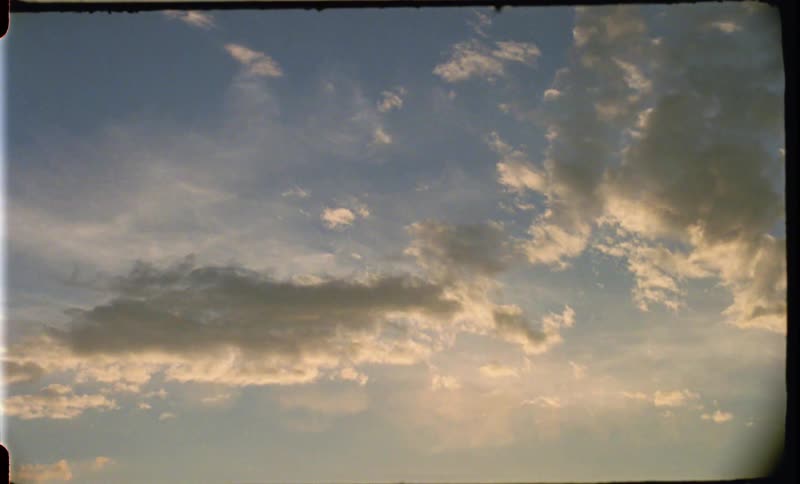 White clouds in the blue sky at sunset caught on film
