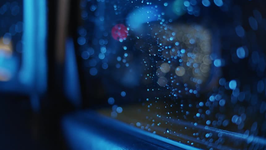 Wet window of a car driving at night