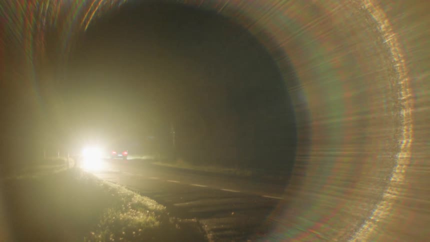 Vehicles pass each other on a curvy road at night
