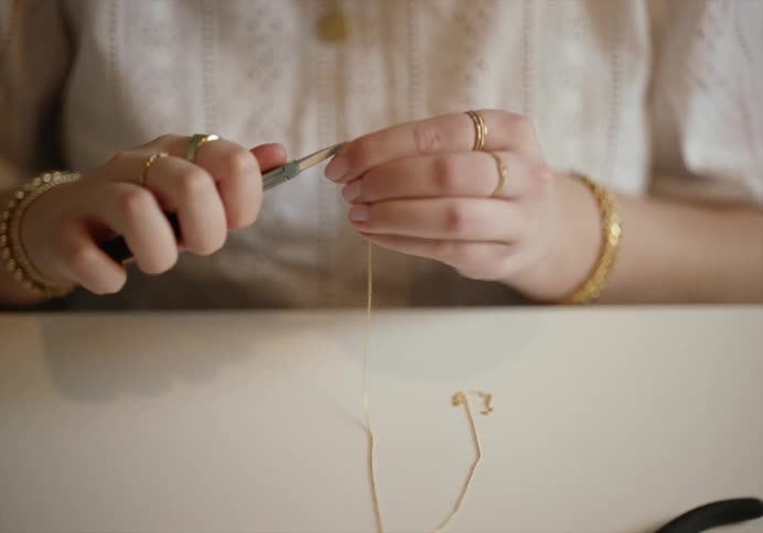 Woman sitting in a table hand crafting jewlery accessories